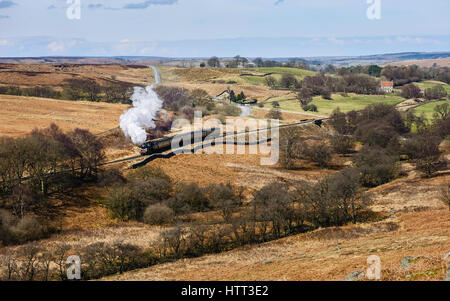 A vintage steam train chugs through the North York Moors national park on a fine spring morning near Goathland, Yorkshire, Stock Photo