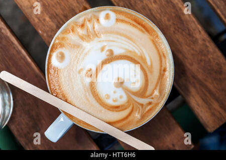 Latte art bear on wooden table Stock Photo