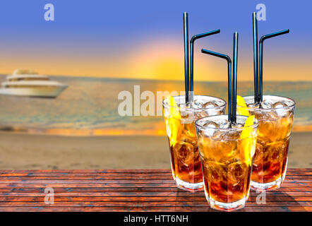 Three cuba libre exotic tasty cocktails background beach and turquoise sea Stock Photo