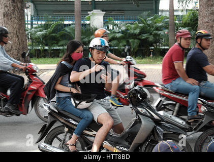 Ho Chi Minh city, Viet Nam, Vietnamese people stop motorbike, play pokemon go, hot game on smart phone, gamer sit on motorcycle, Tao Dan park, Vietnam Stock Photo