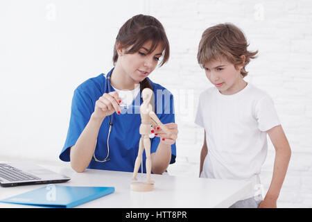 Doctor explain medicine to child using wooden doll Stock Photo