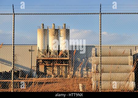 A manufacturing business secured behind a chain link fence, topped by barb wire in this industrial setting in Bartlett, Illinois.USA. Stock Photo