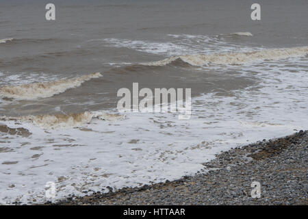 Gentle waves break on a Spring tide in Cromer, Norfolk. Stock Photo