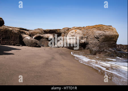 Vagator Beach in North Goa, face of Shiva carved in to a large rock Stock Photo