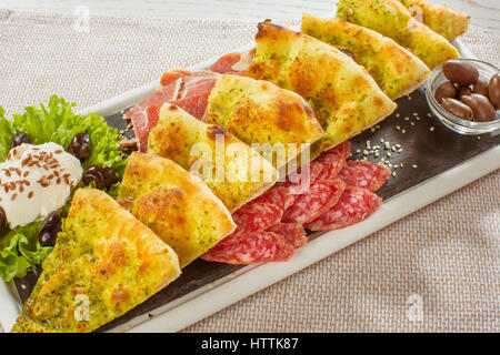 Pizza pieces lying on the faded textural dark black background in a row, copy space at the top Stock Photo