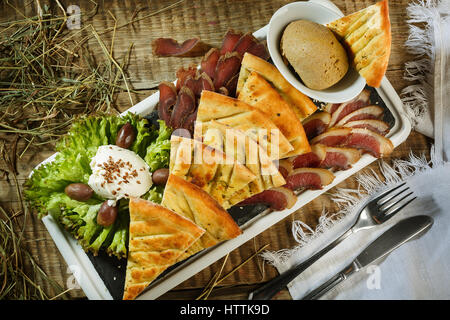 Pizza pieces lying on the faded textural dark black background in a row, copy space at the top Stock Photo