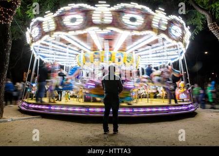 Carousel in motion with immobile man at Christmas Fair Stock Photo