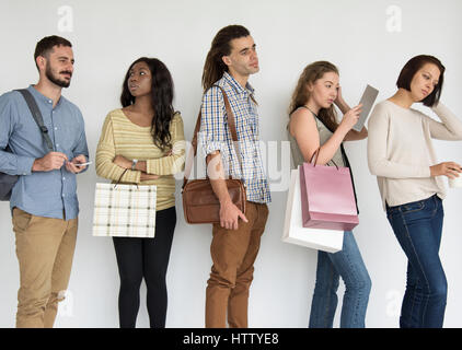 Diverse group of people standing in a queue Stock Photo