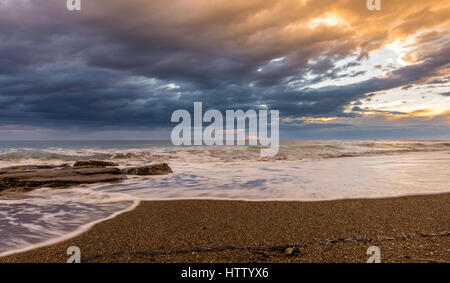 Beatiful sunset on a sandy beach with tide going out. Corfu Greece Stock Photo