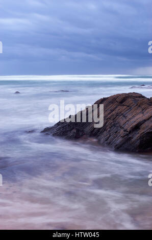 Stormy sky and blurred waves on Praia do Farol, Vila Nova de Milfontes, Alentejo, Portugal. Stock Photo