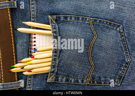 set of school pencils and small notebook in a back pocket of a blue denim jeans Stock Photo