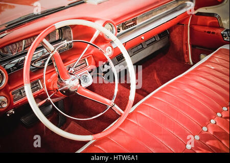 classic american car interior with red leather upholstery and matching dashboard Stock Photo