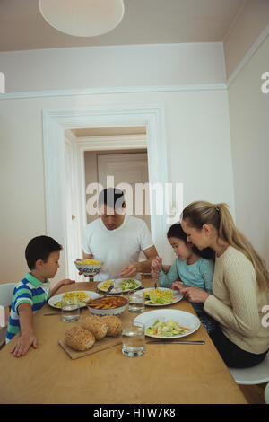 Family having meal on dining table Stock Photo
