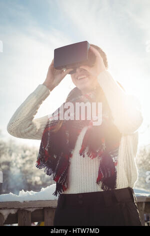 Woman in winter wear using VR headset Stock Photo