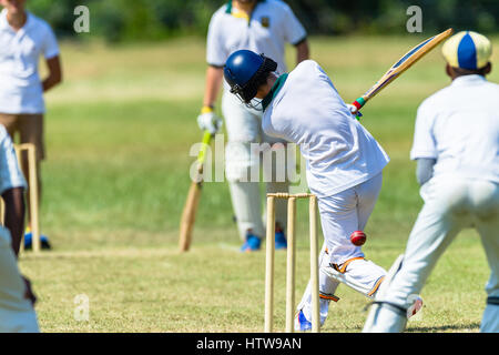 Cricket game players batsman ball fielders action teenagers schools Stock Photo