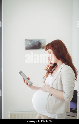 Pregnant woman using digital tablet in study room Stock Photo