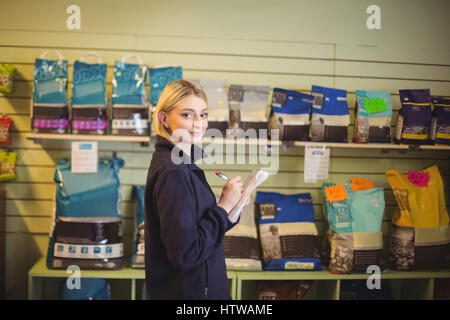 Woman writing on notepad in shop Stock Photo