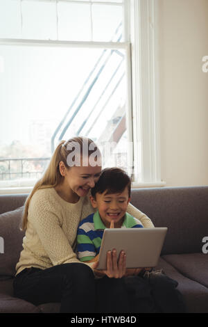 Mother and son using digital tablet in living room Stock Photo