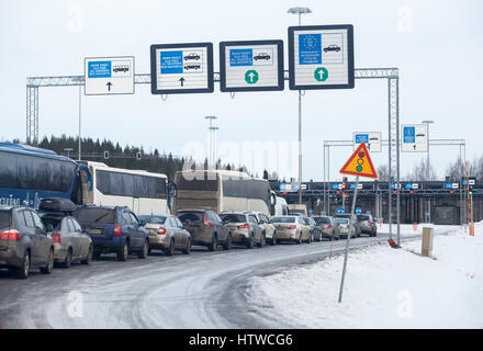 NUIJAMAA, FINLAND - CIRCA FEB, 2017: Passenger busses and cars stand in long queue for custom and border control at winter season. Nuijamaa is the bus Stock Photo