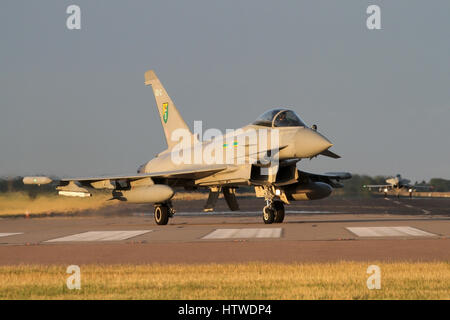 RAF Typhoon rolling off the end of the runway after landing at RAF Coningsby. Taken in the 'golden hour' prior to sunset. Stock Photo