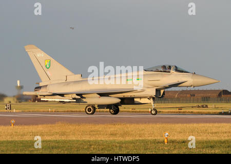 One RAF Typhoon turning off the runway at RAF Coningsby as another turns for landing. Taken in the 'golden hour' just prior to sunset. Stock Photo