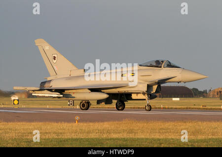 RAF Typhoon rolling off the end of the runway after landing at RAF Coningsby. Taken in the 'golden hour' prior to sunset. Stock Photo