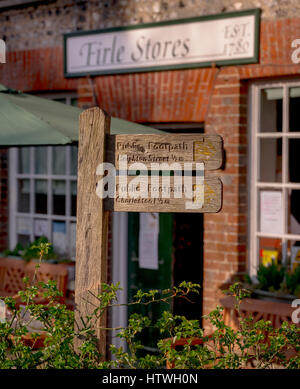 Two public footpath signs to Charleston and Heighton Street outside the village stores and post office in the village of Firle in East Sussex near Le Stock Photo