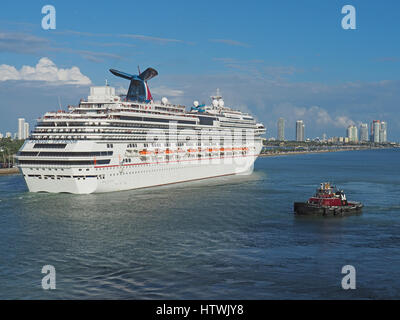 Carnival Splendor cruise ship assisted by tugboat leaving Port of Miami. Stock Photo