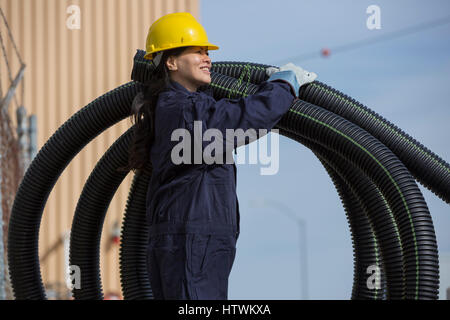 Female power engineer moving flexible drainpipes Stock Photo