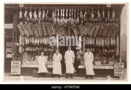 Original Edwardian era postcard photograph of Liggett's butcher's shop, meat displayed in window, group of men - staff or assistant, assistants, apprentices, standing outside, Bootle, Liverpool, England, U.K. circa 1913 Stock Photo