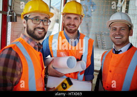 Three constructors on construction-site looking at camera Stock Photo
