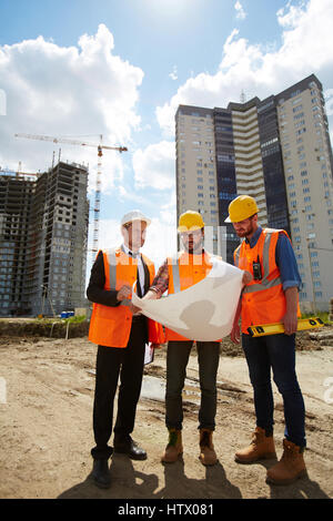 Foreman with sketch explaining his co-workers principles of new project Stock Photo