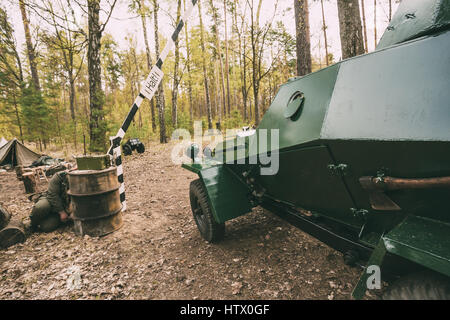 Russian Armoured Soviet Scout Car Ba-64 Of World War II Near German Checkpoint With Open Barrier On Forest Road. Vehicle Of Red Army. Killed German So Stock Photo