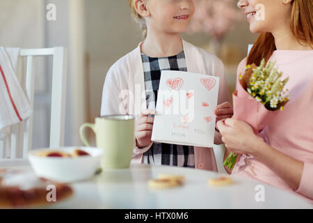 Girl holding self-made greeting-card for her mother Stock Photo