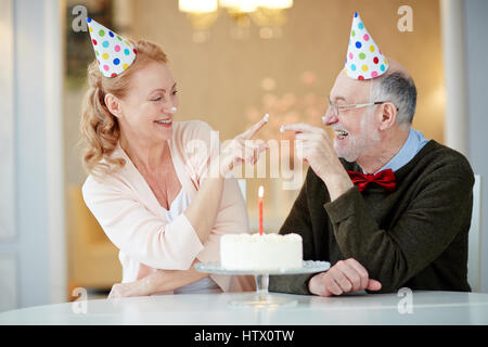 Portrait of playful senior couple laughing and having fun celebrating birthday together Stock Photo