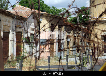 Abandoned buildings behind rusting barbed wire in the buffer zone between the Greek and Turkish sides of central Nicosia, Cyprus Stock Photo
