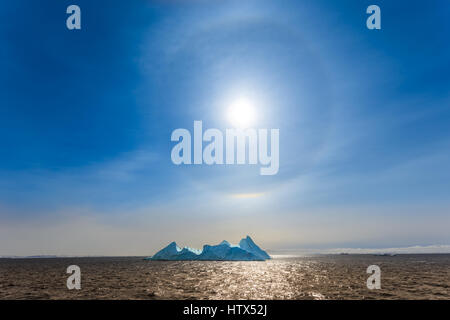 Sun Halo shining over the blue iceberg and ocean, North Greenland Stock Photo