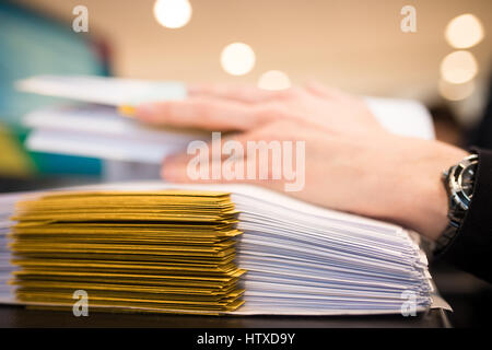 Close-up of female hand with dossiers at the office . Working on stack of files. Shallow DOF Stock Photo