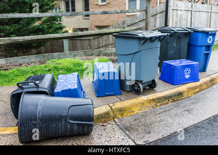 Trash cans outside on curb with recycle bins in neighborhood Stock Photo