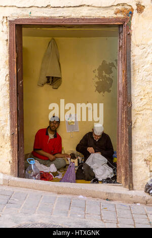 Fes, Morocco.  Two Tailors at Work inside their Shop in the Medina. Stock Photo