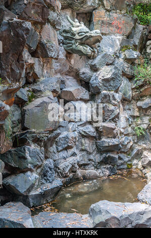 China, Hangzhou. Monastery Soul SanctuaryTemple (Lininsy). Drip Fountain 'Dragon', embedded in the rock wall. Stock Photo