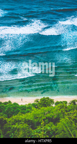 Man walking along of Nunggalan Beach. Big waves rolling on. Uluwatu, Bali, Indonesia Stock Photo