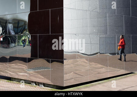 Reflection of a woman in the mirror cube designed by Aziz Bekkaoui, located between the Stedelijk Museum and the Van Gogh Museum in Amsterdam Stock Photo