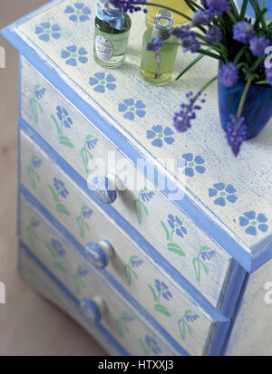 Close-up of a painted chest of drawers with a stenciled floral pattern Stock Photo