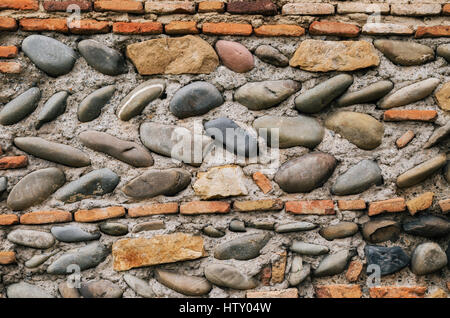 Ancient georgian natural stone wall of different sizes and brick. Textured background. Stock Photo