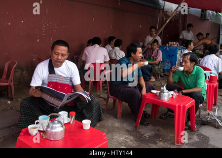 Middle aged men relax and  drink tea at a stall in Pansodan Street, Yangon, Yangon Region, Myanamar Stock Photo