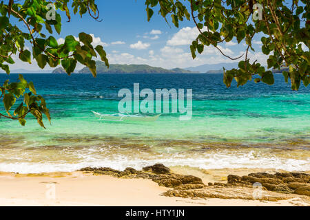 Traditional fisherman banca boat in clear water at Cagnipa Island near Port Barton, Palawan, Philippines Stock Photo