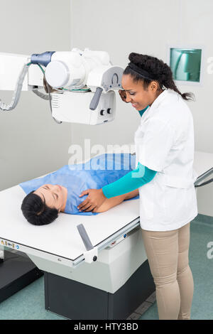 Radiologist Taking X-ray Of Mature Woman Lying On Gurney Stock Photo