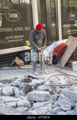 Workers uses jackhammers to break up cement on the street in Manhattan in New York City. Stock Photo