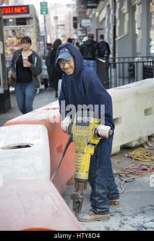 Workers uses jackhammers to break up cement on the street in Manhattan in New York City. Stock Photo